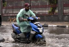 A scooterist wade through a water logged street of Delhi on a rainy day, in the capital on Friday. December 27, 2024. delhi december rain 2024